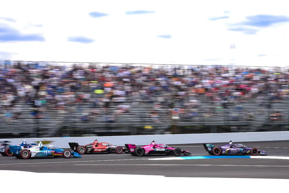 The 2021 IndyCar Series field barrel into turn one at the Indianapolis Motor Speedway.