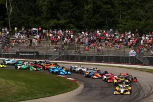 The 2021 NTT IndyCar Series field drives around the Mid-Ohio Sports Car Course.