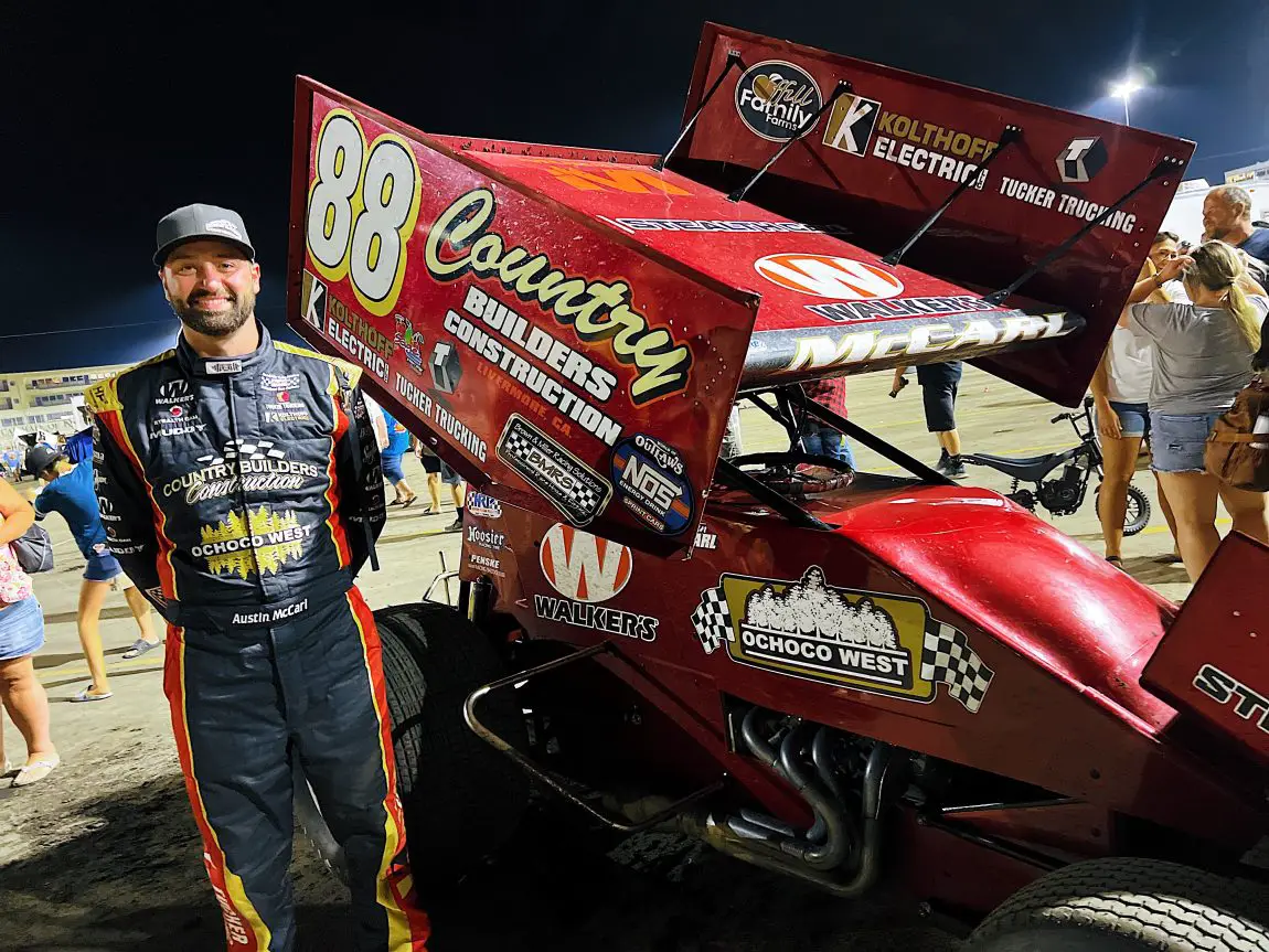 Austin McCarl proudly posing by his car after learning he will lead the field to the 2022 Knoxville Nationals A-Main.