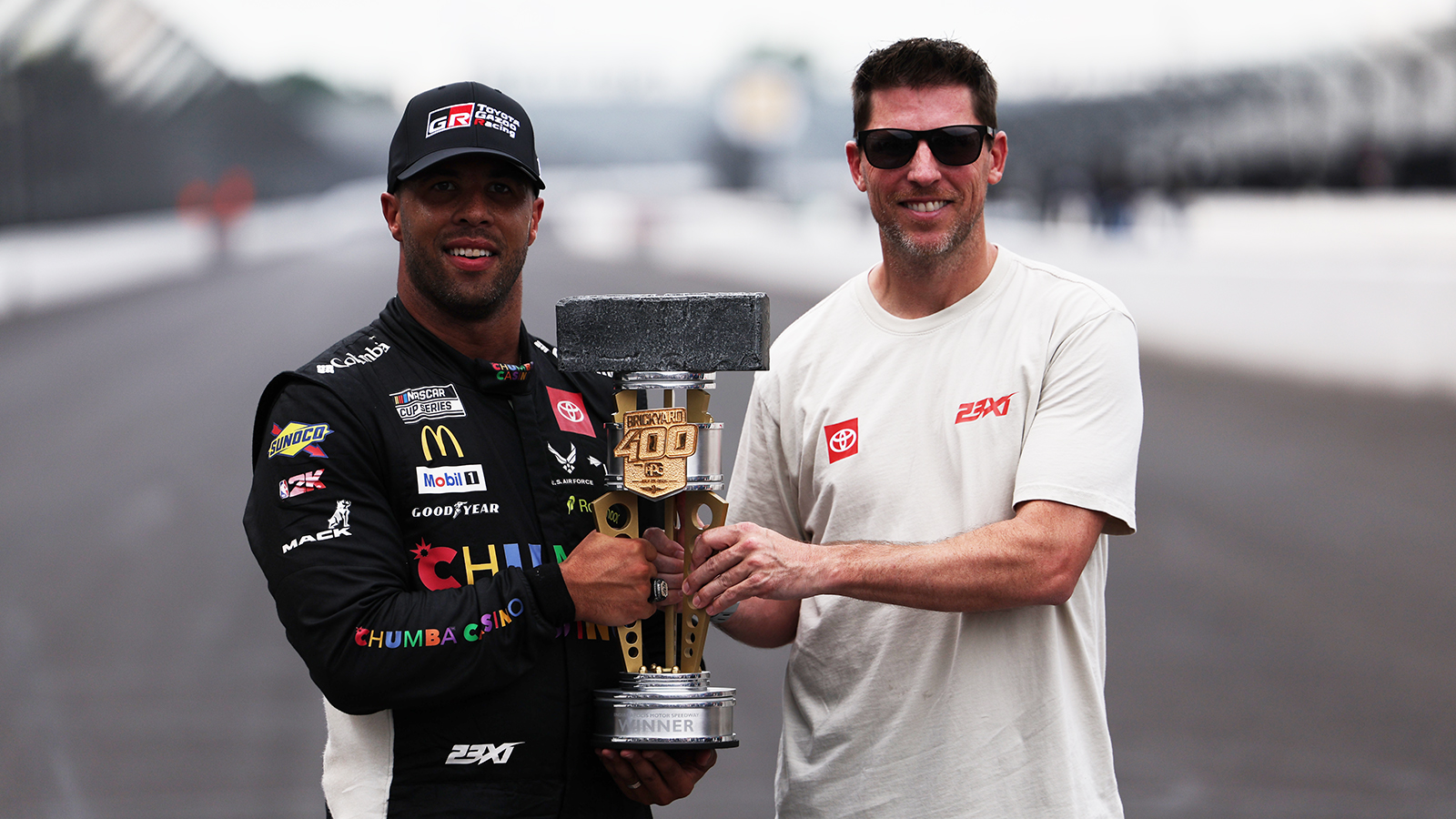 Denny Hamlin feels Bubba Wallace's Brickyard 400 win is the "next step," for the 23XI Racing team and shows that the team belongs in NASCAR.