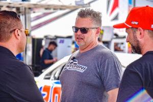 Billy Venturini holds a conversation with Venturini team members at the LVMS Bull Ring.