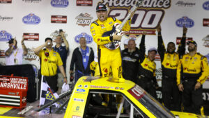 Layne Riggs poses in victory lane with his trophy guitar for winning the Allegiance 200 at Nashville Superspeedway.