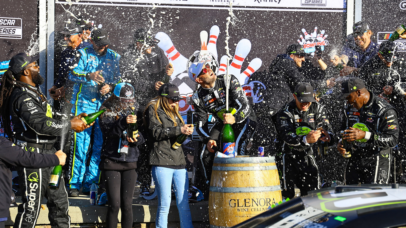 Shane van Gisbergen celebrates with his team in victory lane after a win in the Go Bowling at The Glen