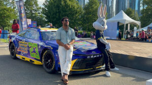 Bubba Wallace poses with Bugs Bunny in front of his No. 23 Upper Deck/Space Jam car at Chicago's Navy Pier
