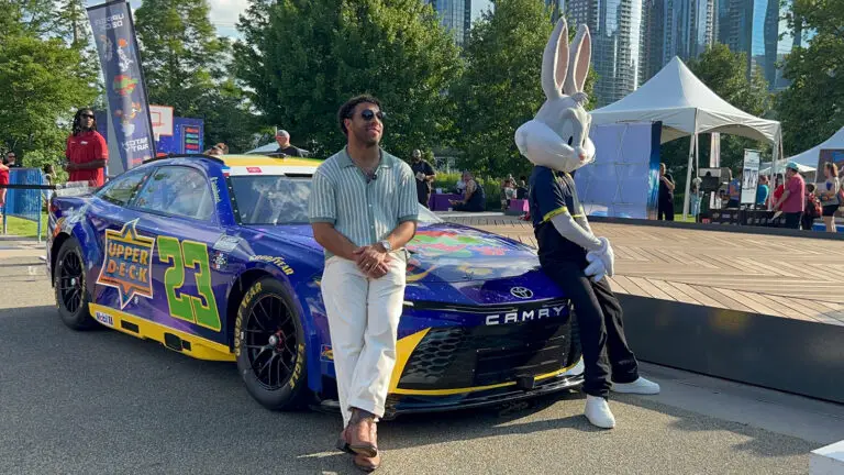 Bubba Wallace poses with Bugs Bunny in front of his No. 23 Upper Deck/Space Jam car at Chicago's Navy Pier