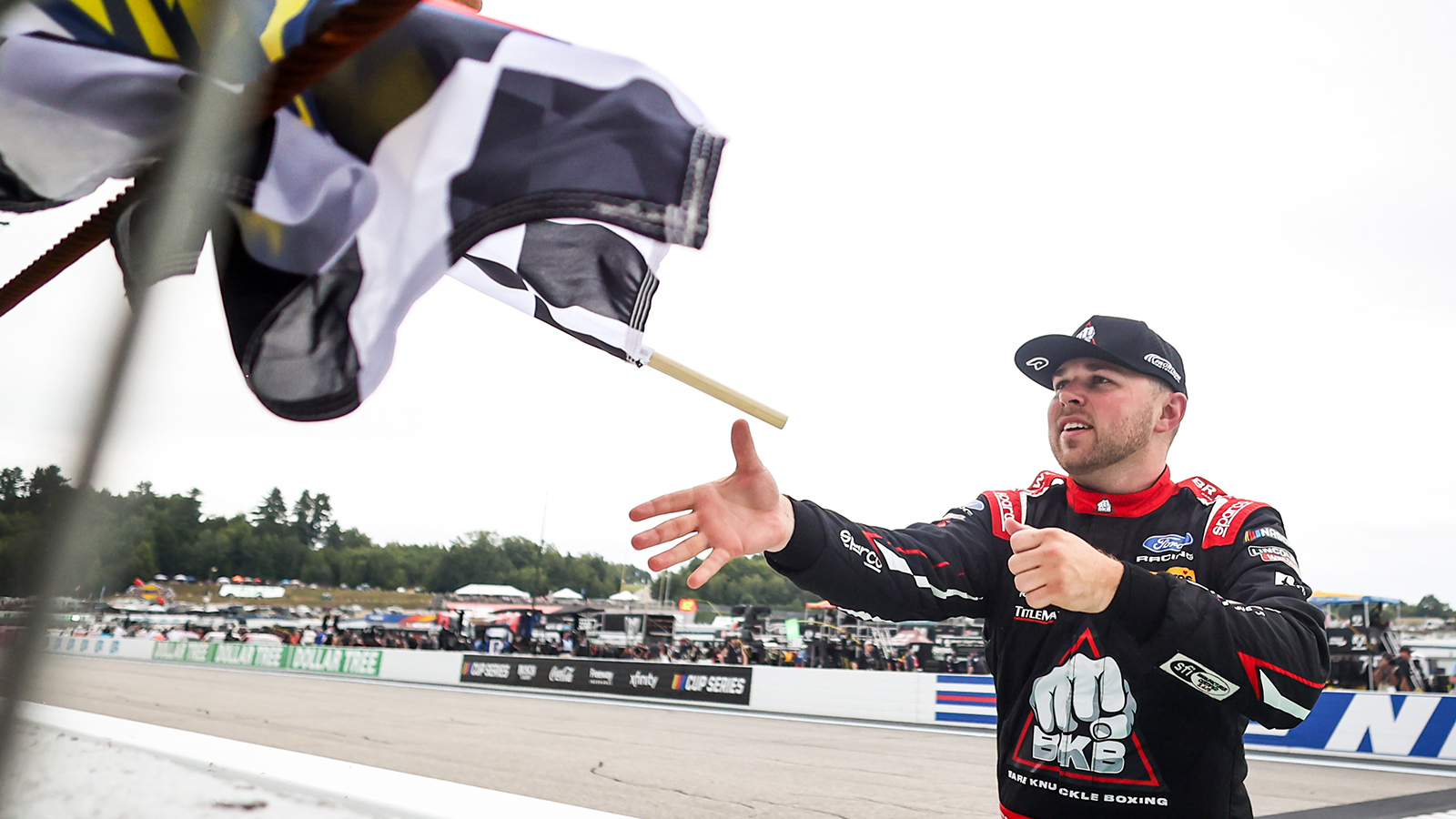 Layne Riggs collects the checkered flag after winning the Team EJP 175 at New Hampshire Motor Speedway