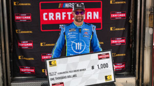 Shane van Gisbergen poses with the oversized check after winning the pole for the Black's Tire 250 at Richmond Raceway.