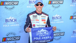 Denny Hamlin holds up the pole award flag after winning the pole for the South Point 400 at Las Vegas Motor Speedway.