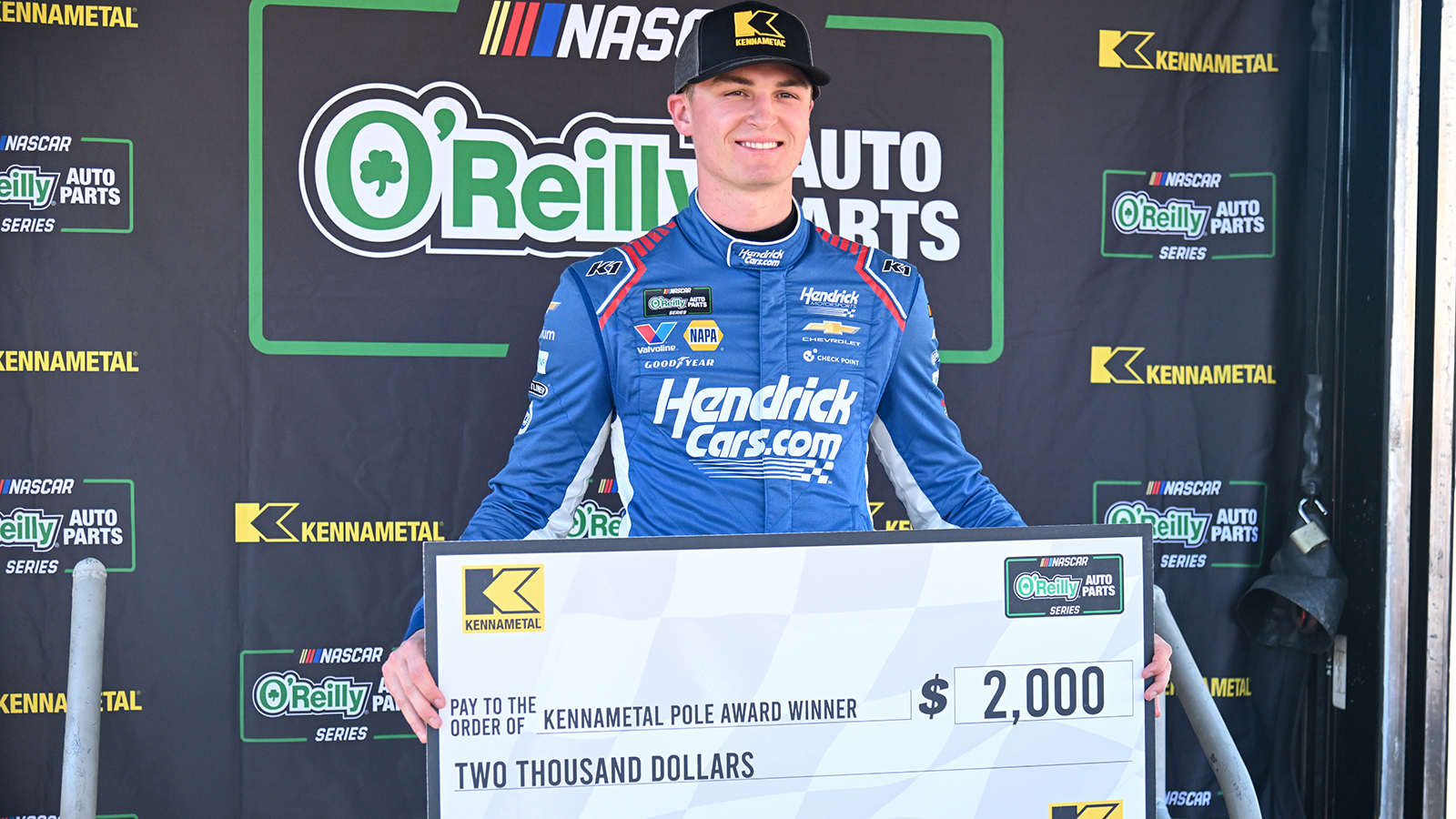 Corey Day poses with an oversized pole award check after winning the pole for the Focused Health 302 at Las Vegas Motor Speedway.